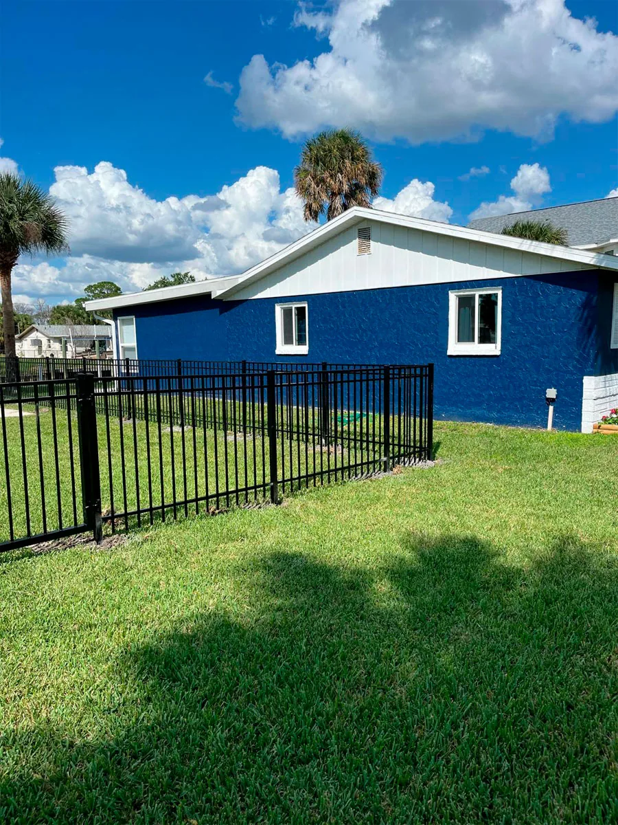 Black aluminum fence at a landscaped residential yard