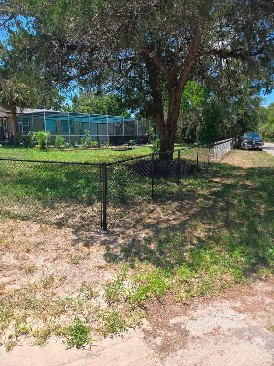 Black chain link fence installed along a residential property