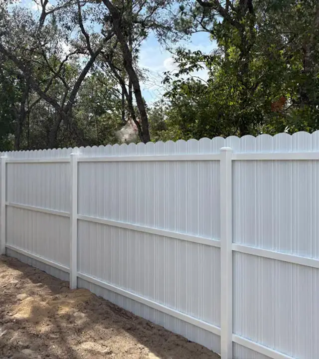 White Durafence steel privacy fence with a scalloped top