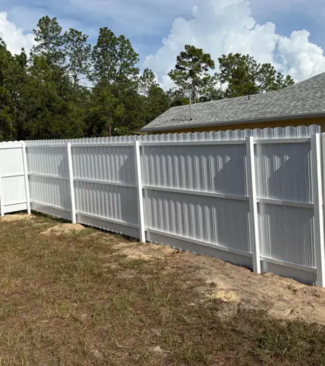 White PVC corner fence in a residential backyard